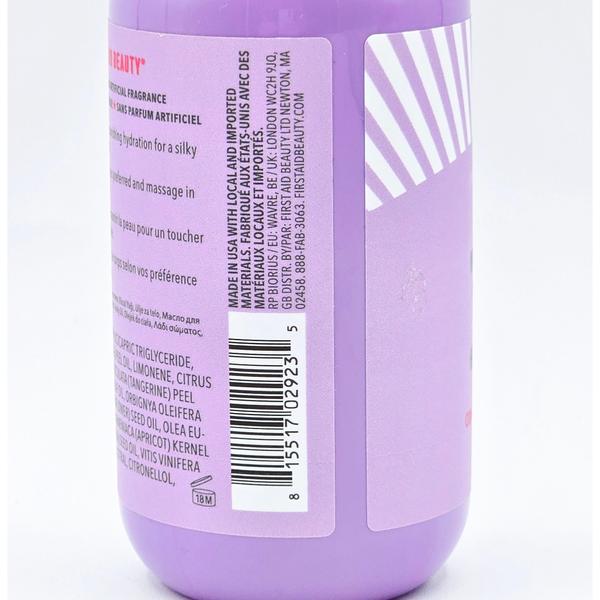 Close-up of a purple First Aid Beauty After Shower Nourishing Body Oil bottle with white label text and barcode.