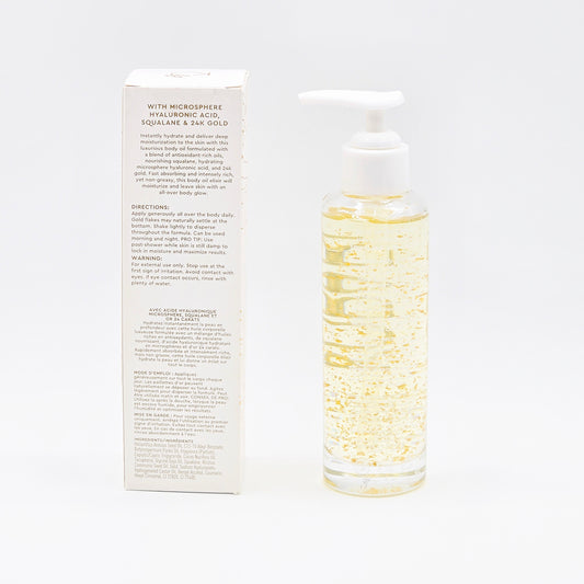 Kopari Golden Aura Body Oil, a clear bottle with gold flakes, next to its white product box.