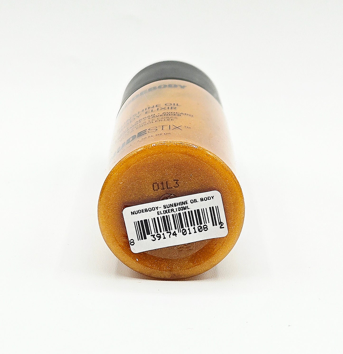 A bottle of Nuredgy Sunshine Oil Body Oil shown from the bottom, displaying the amber-colored oil inside and a white barcode label with a black barcode.