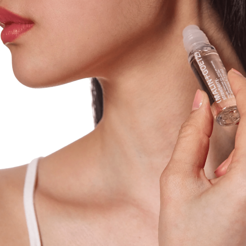 Woman holding a skincare product close to her neck