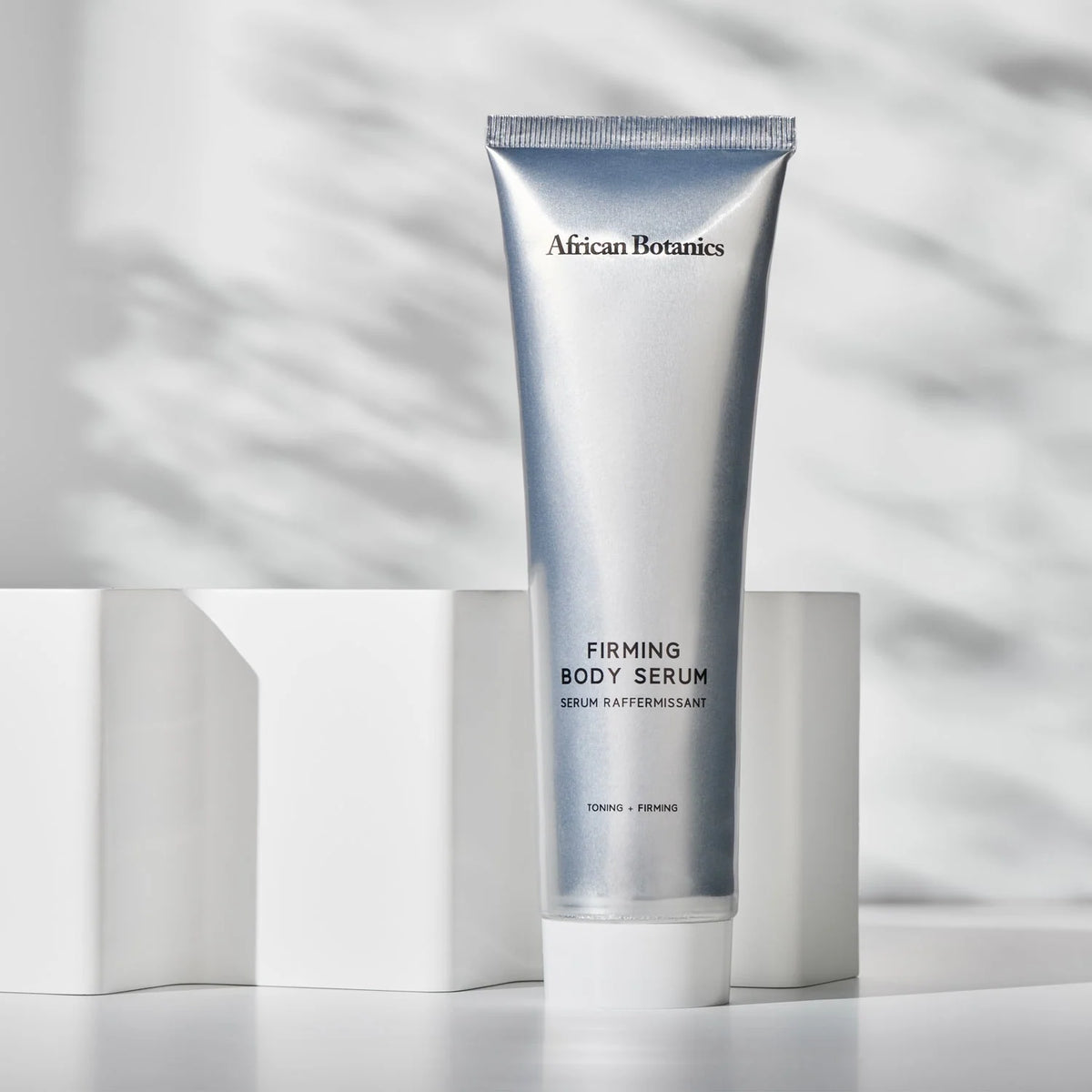 African Botanics Firming Body Serum tube displayed on white blocks