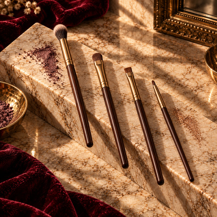 Blending, shader, angled liner, and detail eye brushes with cacao handles on a warm fall luxury vanity