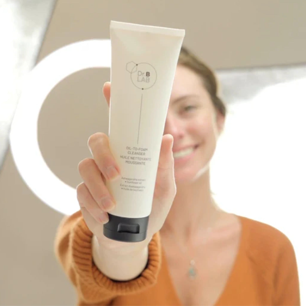 Person holding Dr. B Lab Oil-to-Foam Cleanser tube