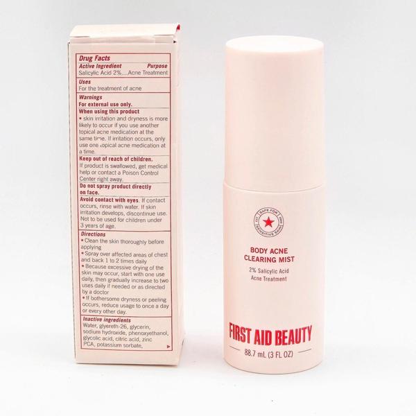 First Aid Beauty Body Acne Clearing Mist, a pale pink 3 fl oz bottle with a matching cap, next to its white box.