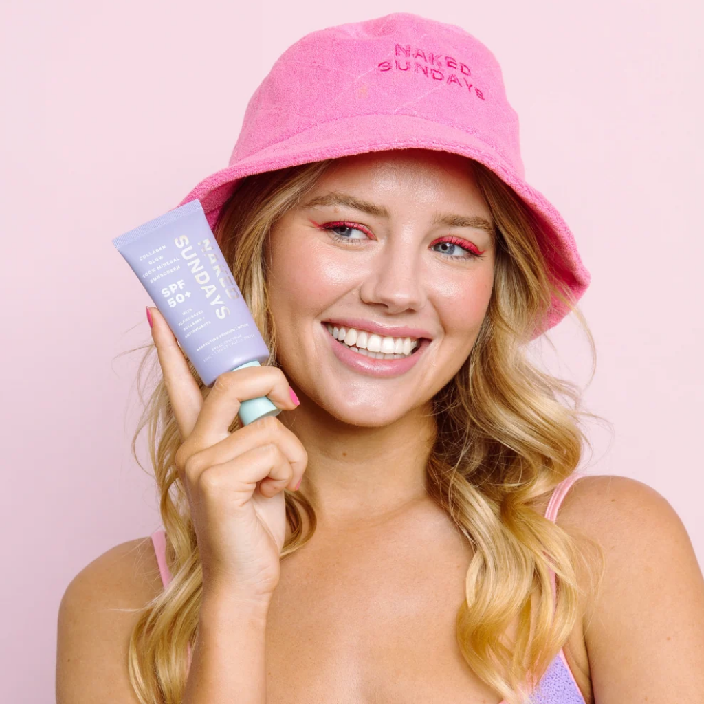 Brand model holding Naked Sundays Collagen Glow sunscreen