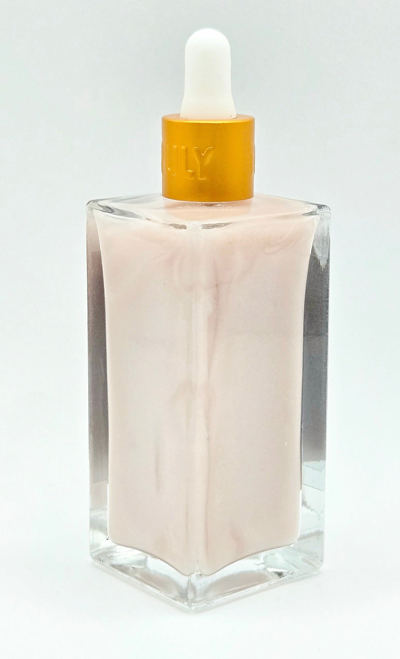 Light pink glass dropper bottle with gold cap on a white background