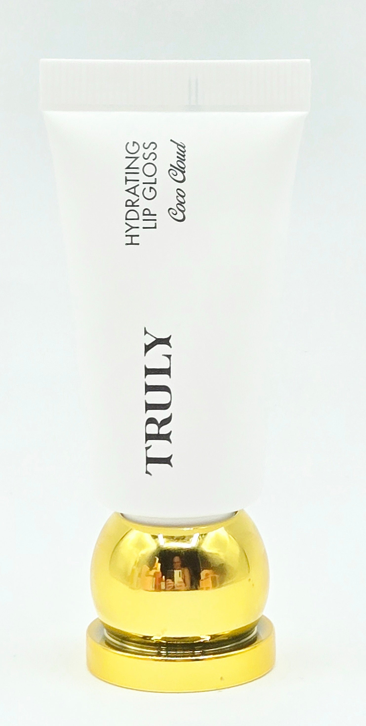 Lip gloss with gold cap and white container on a light gray background