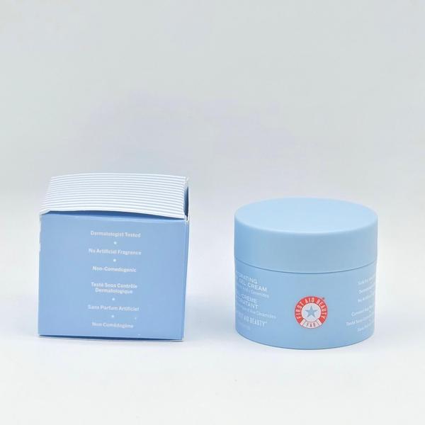 First Aid Beauty Hydrating Dewy Gel Cream in a light blue jar with a matching box.