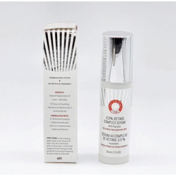 First Aid Beauty 0.3% Retinol Complex Serum in a white bottle with silver cap next to its white box.