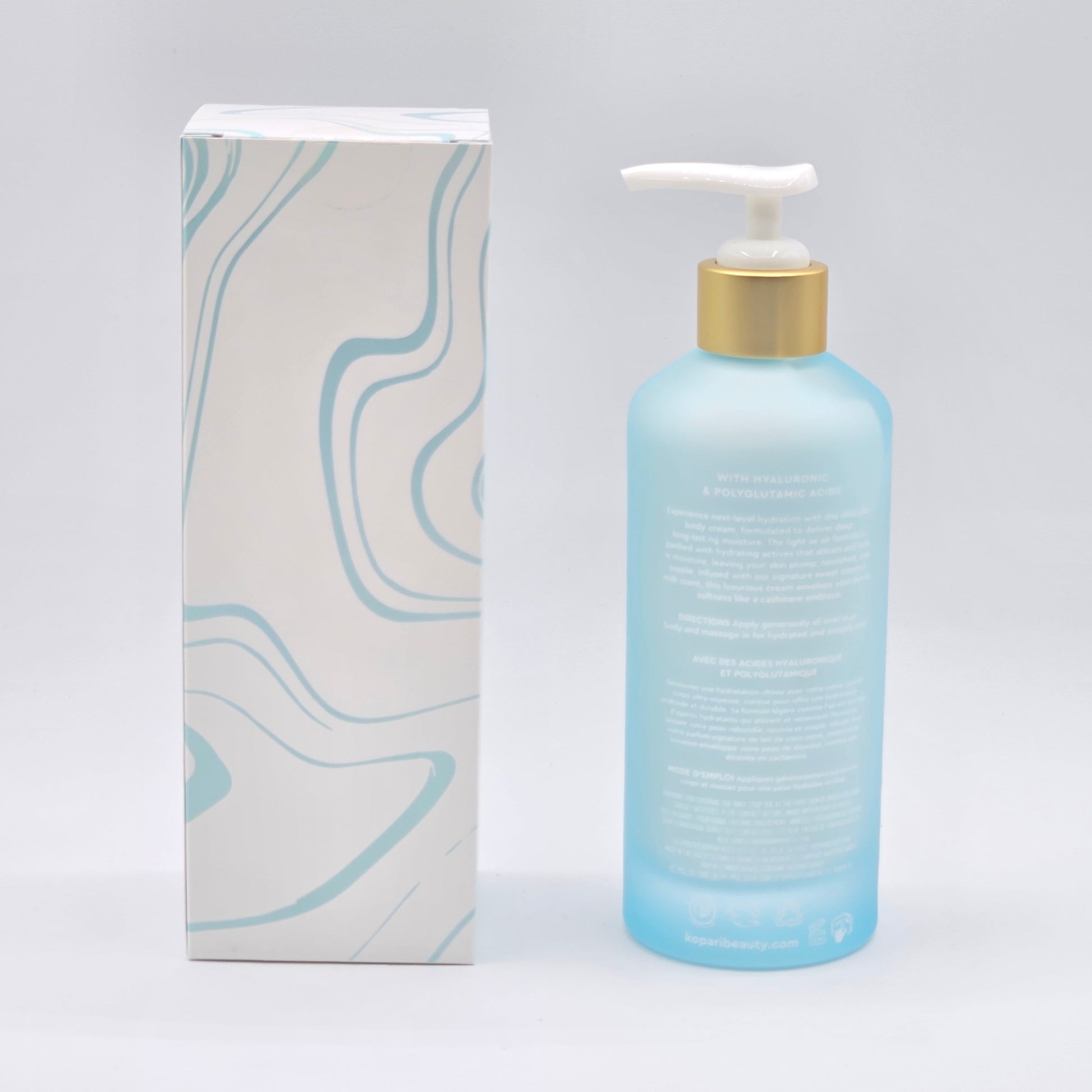 Kopari Hydrating Silk Body Cream: 6.6 fl oz blue bottle with gold pump next to a white box with blue waves.