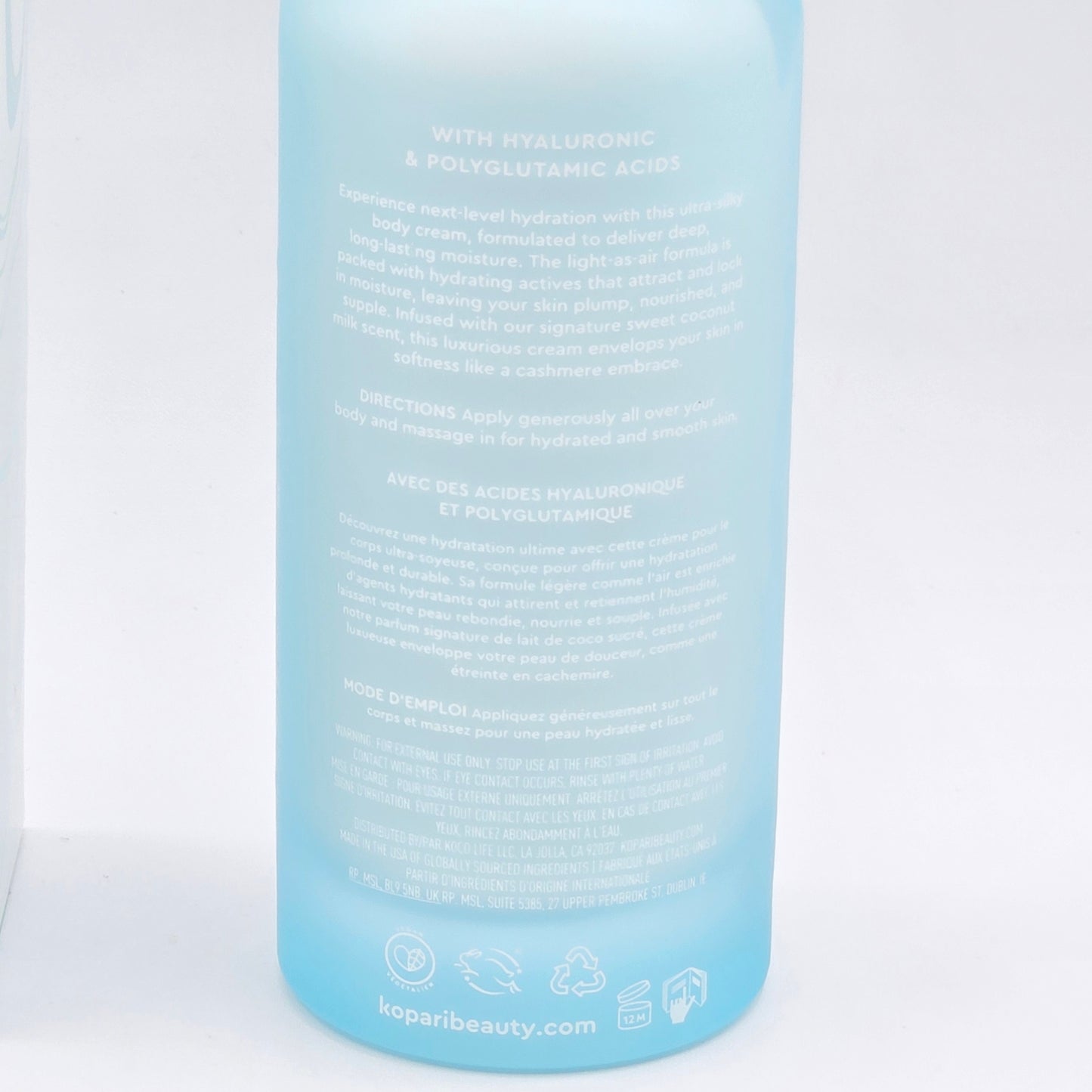 Light blue Kopari Hydrating Silk Body Cream bottle with white text, showing product description and branding.