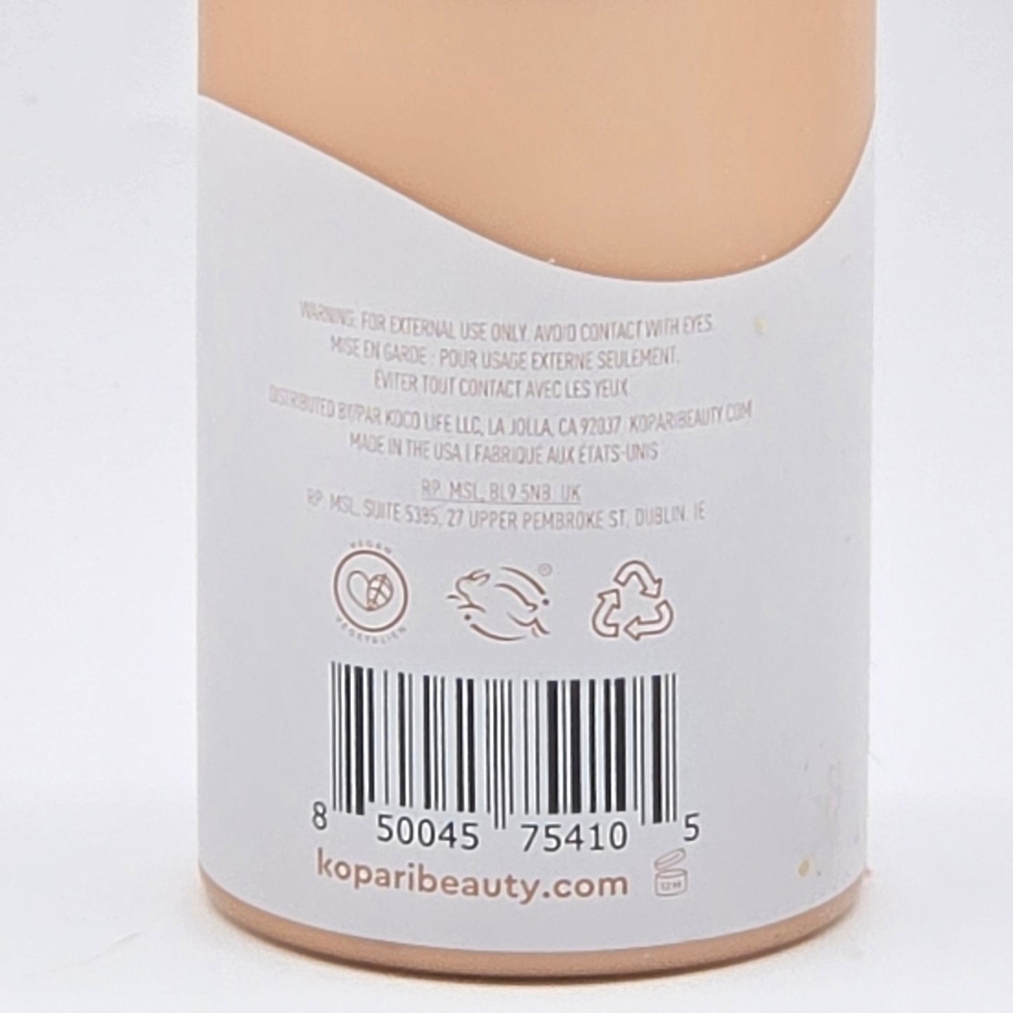Back of Kopari Tahitian Vanilla Hydrating Body Milk bottle, showing barcode, vegan, cruelty-free, and recycling symbols.