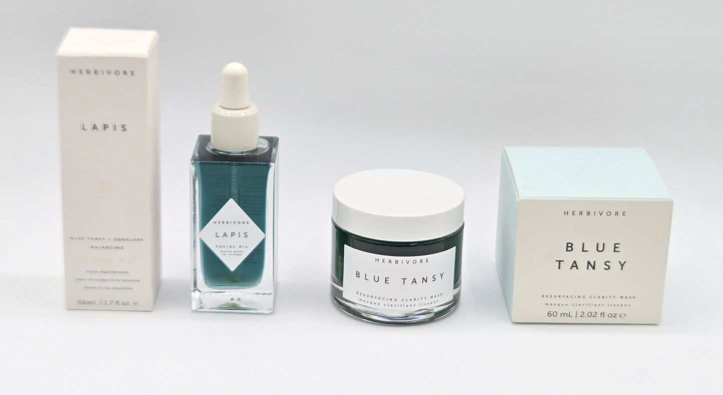 Herbivore Blue Tansy skincare products including a dropper bottle, jar, and boxes on a white background