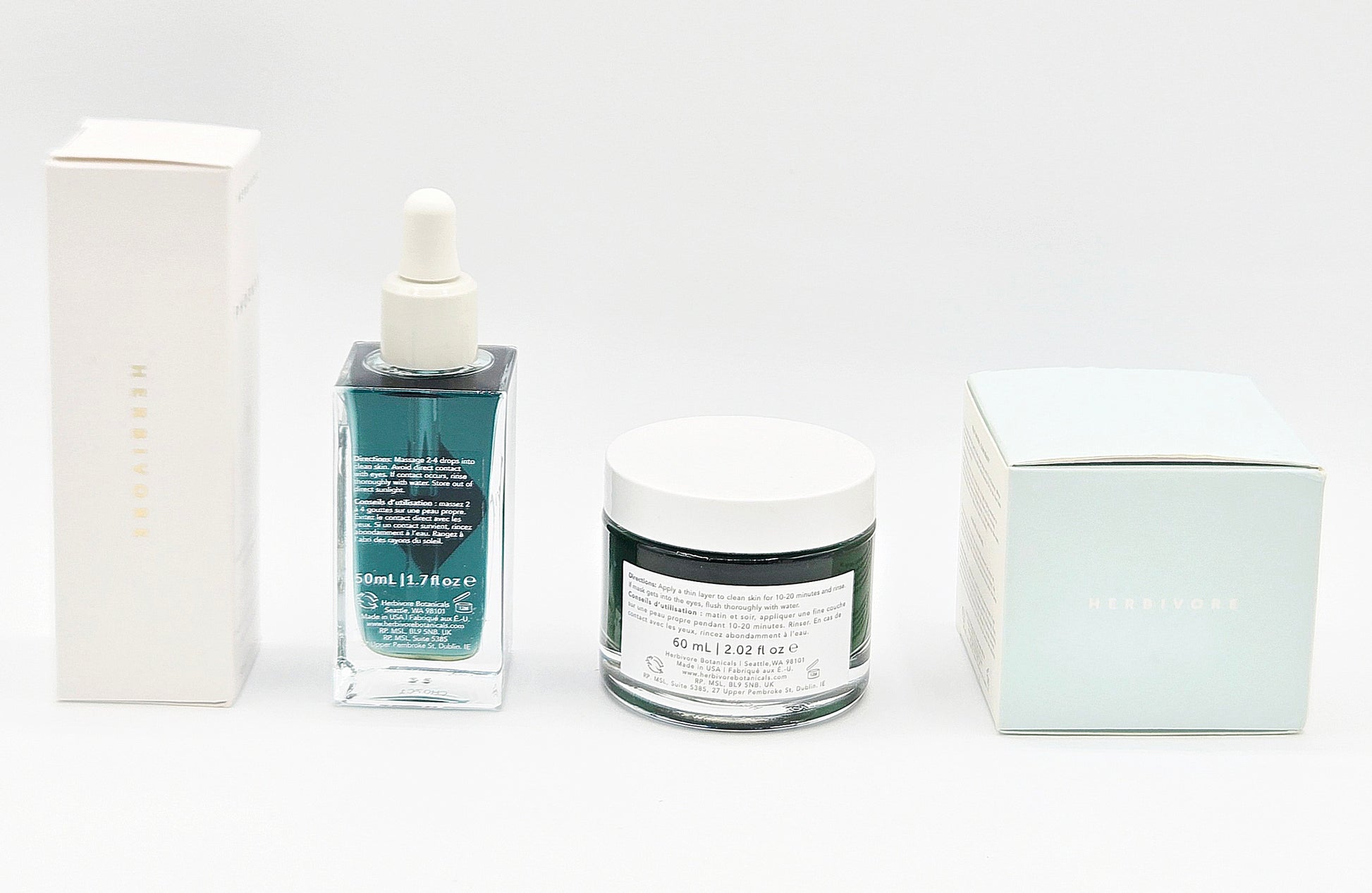 Skincare products including a dropper bottle, jar, and boxes on a white background