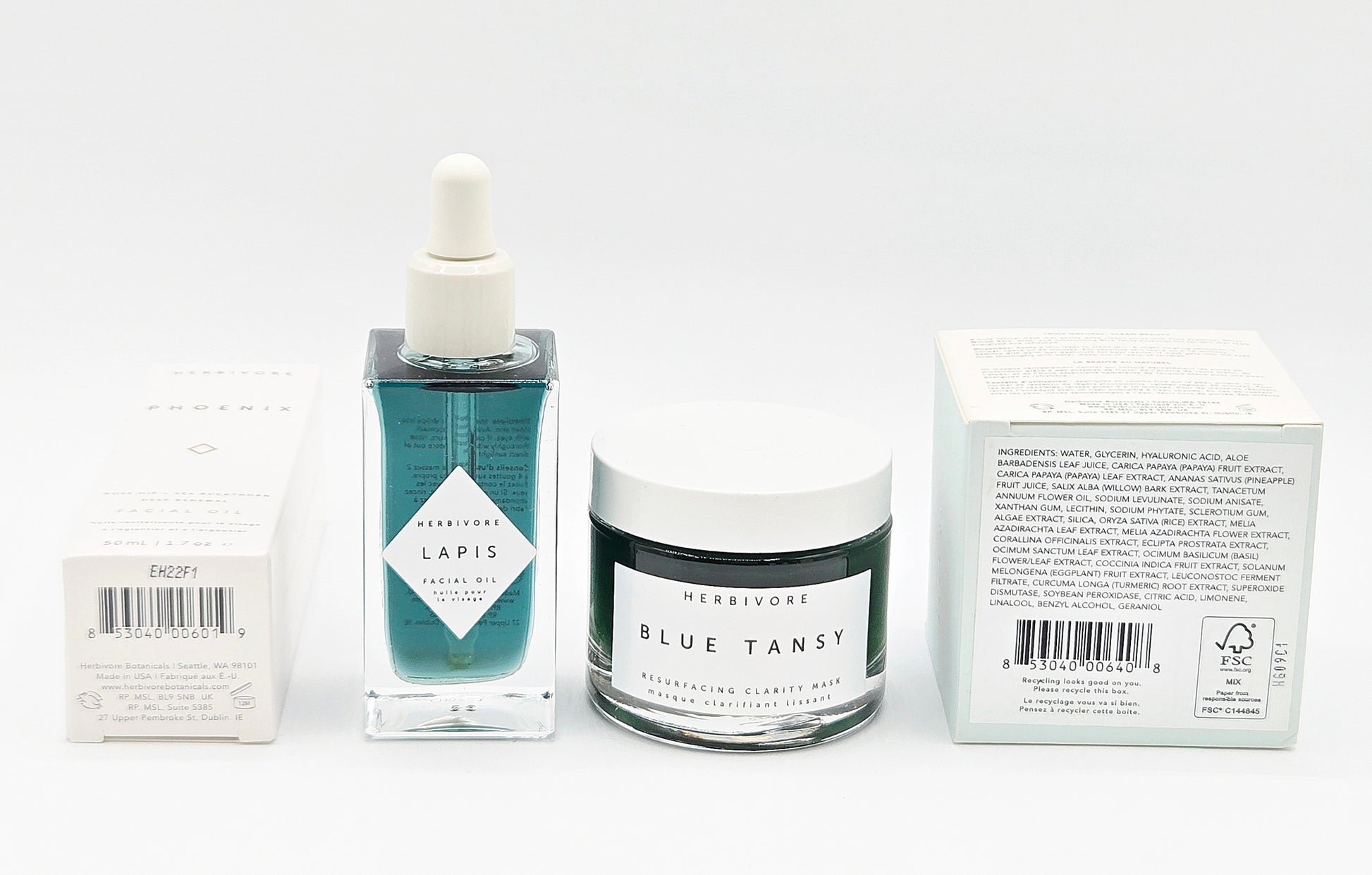 Skincare products including a dropper bottle, jar, and boxes on a white background