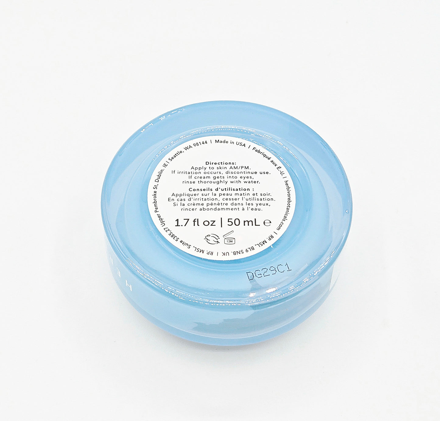 Small blue jar with a white label on a white background