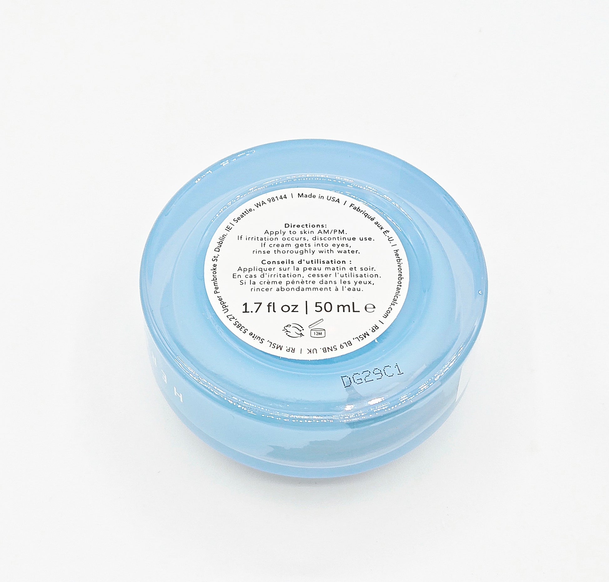 Small blue jar with a white label on a white background