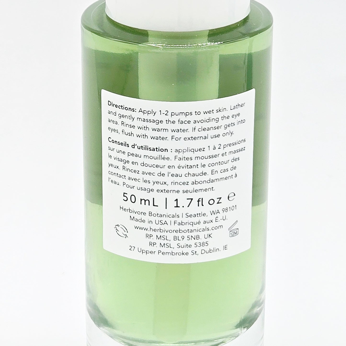 Green skincare bottle with label on a white background