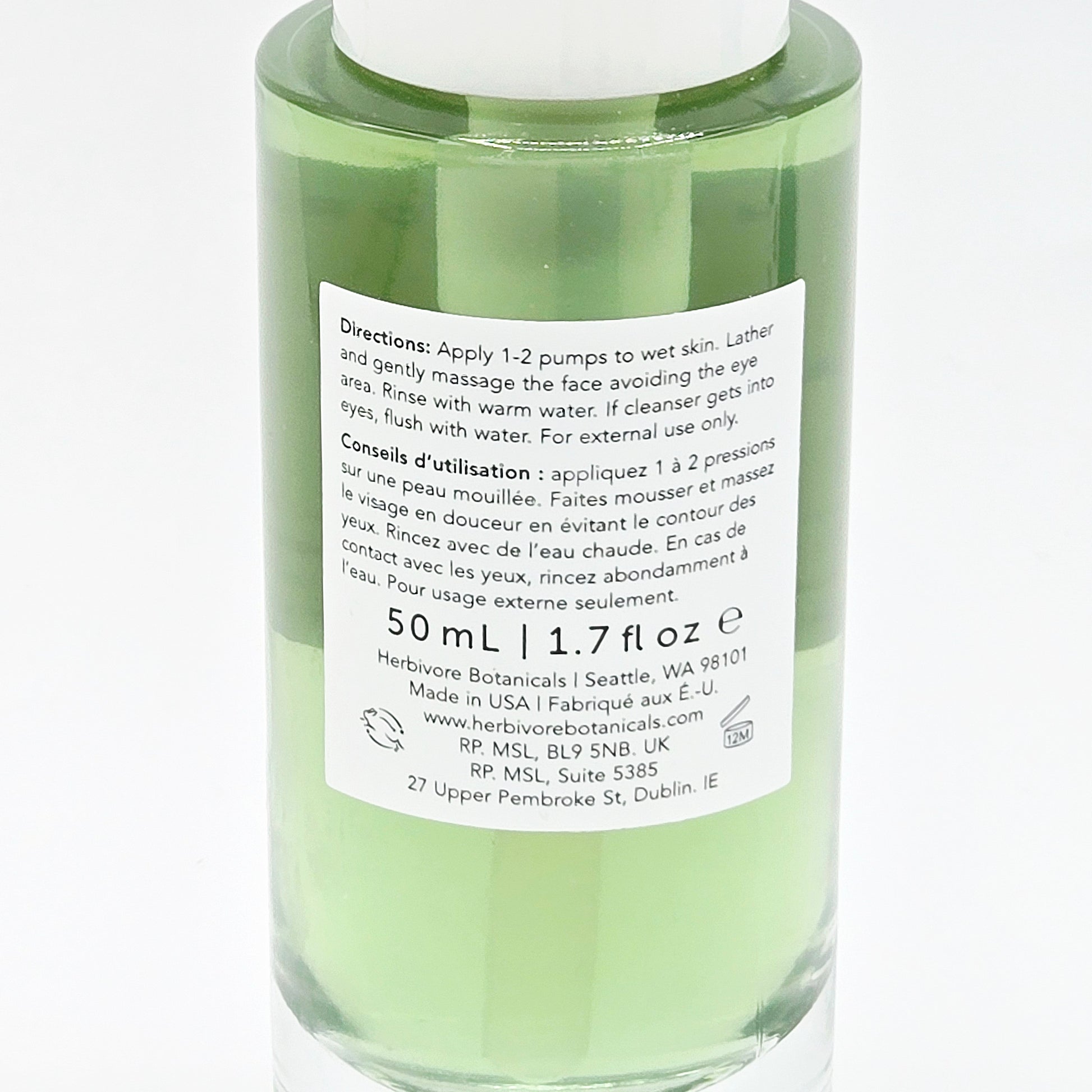 Green skincare bottle with label on a white background