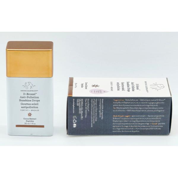 Drunk Elephant D-Bronzi Anti-Pollution Sunshine Drops, 30ml, with a white bottle and gold cap, next to its brown and white box.