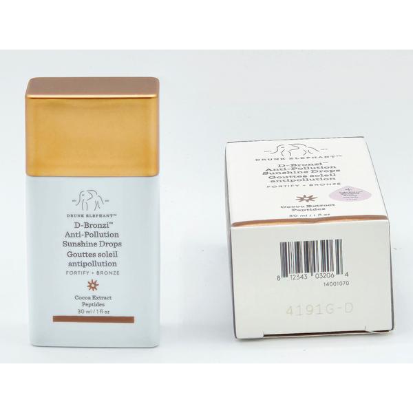 Drunk Elephant D-Bronzi Anti-Pollution Sunshine Drops in a white bottle with a gold cap, next to its white box.