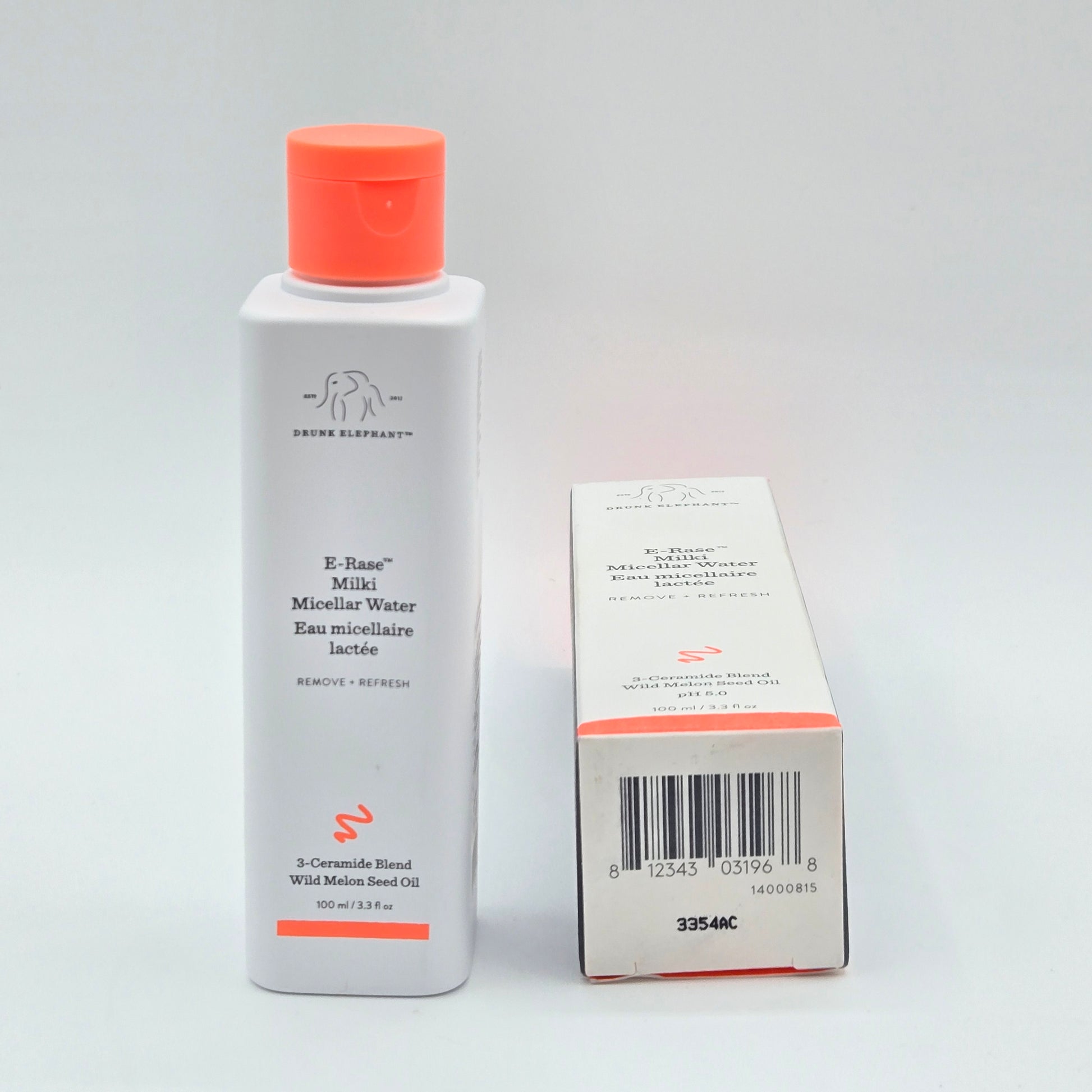 Tube of skincare product with coral cap and white body on a light gray background