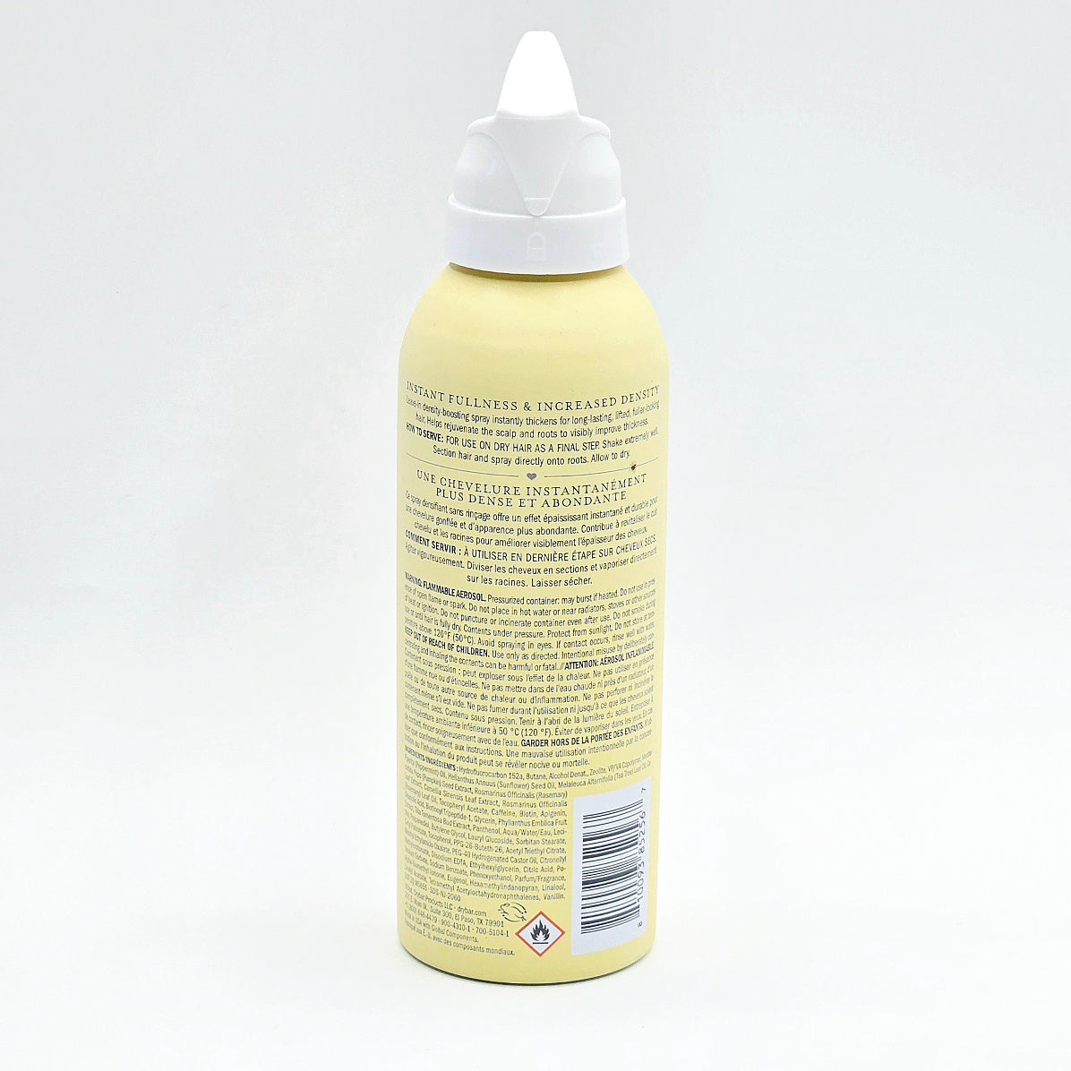 The back of a pale yellow squeeze bottle with a white pointed cap, showing product text and a barcode on a white background.