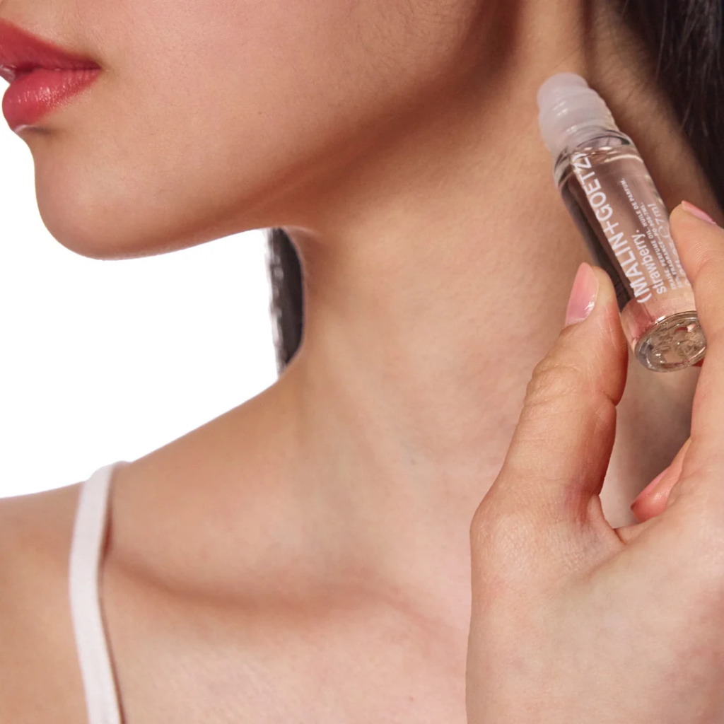 Woman holding a skincare product close to her neck