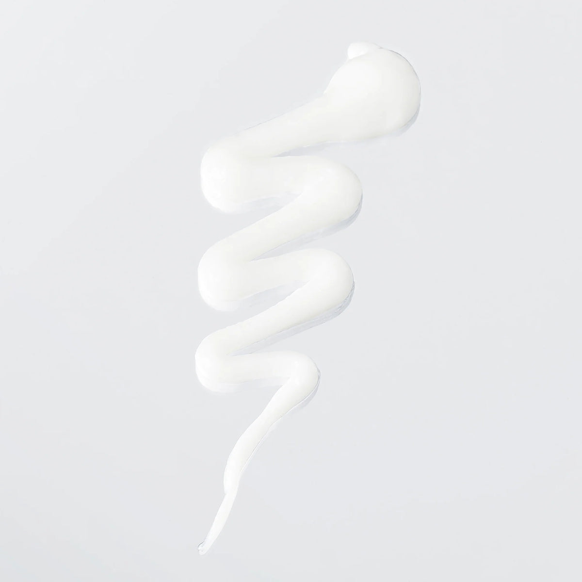White Verb Hydrate Styling Cream in a curved ribbon swatch on a light background, showing its smooth texture.