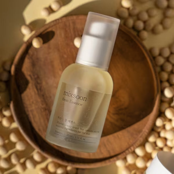 mixsoon Bean Essence bottle on a wooden dish surrounded by soybeans
