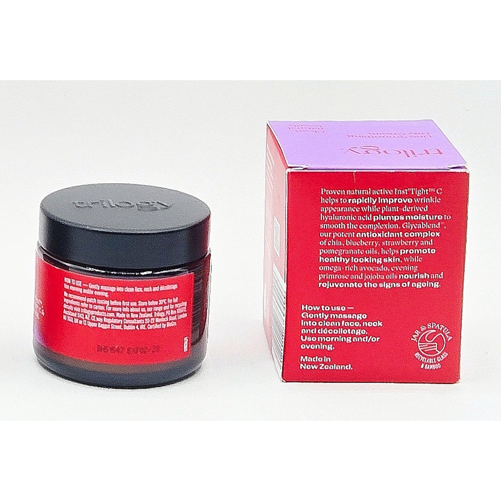 Cosmetic jar with red label and black lid next to its packaging box on a white background