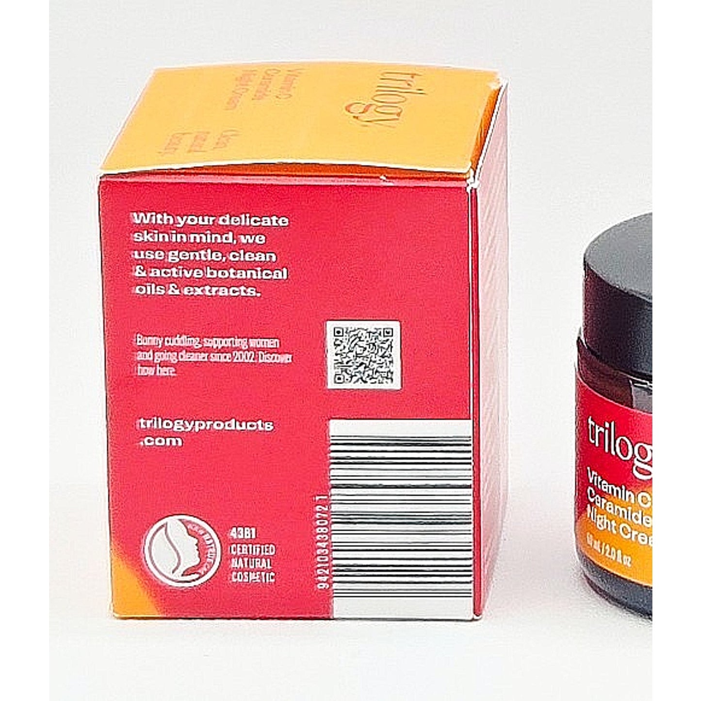 Trilogy skincare product packaging with red box and jar on a white background