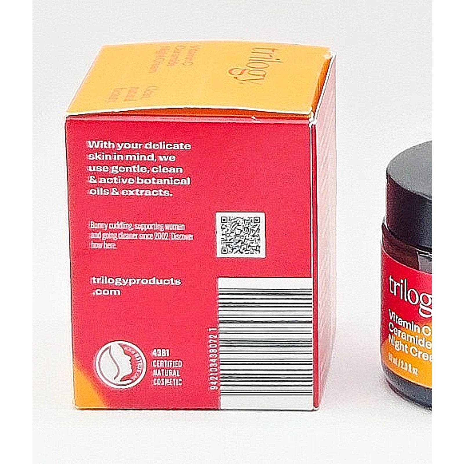 Trilogy skincare product packaging with red box and jar on a white background