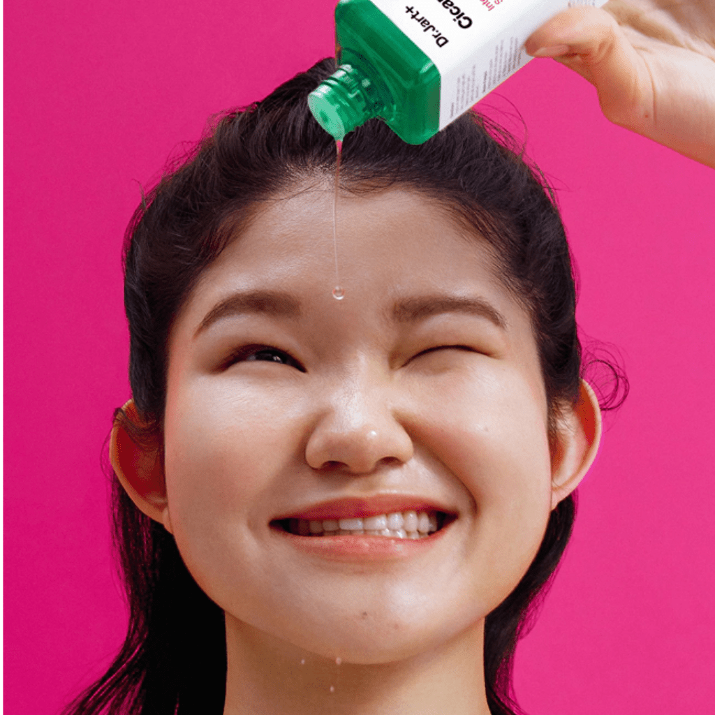 Model applying Dr. Jart+ Cicapair Intensive Soothing Repair Serum to her forehead.