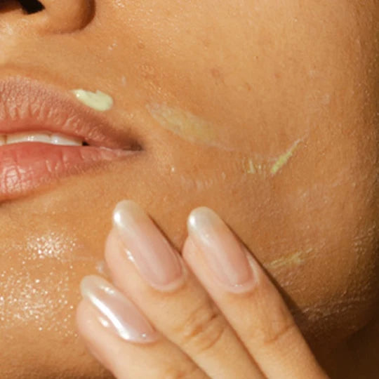 Model massaging Odacité Derm-Restore serum onto her cheek
