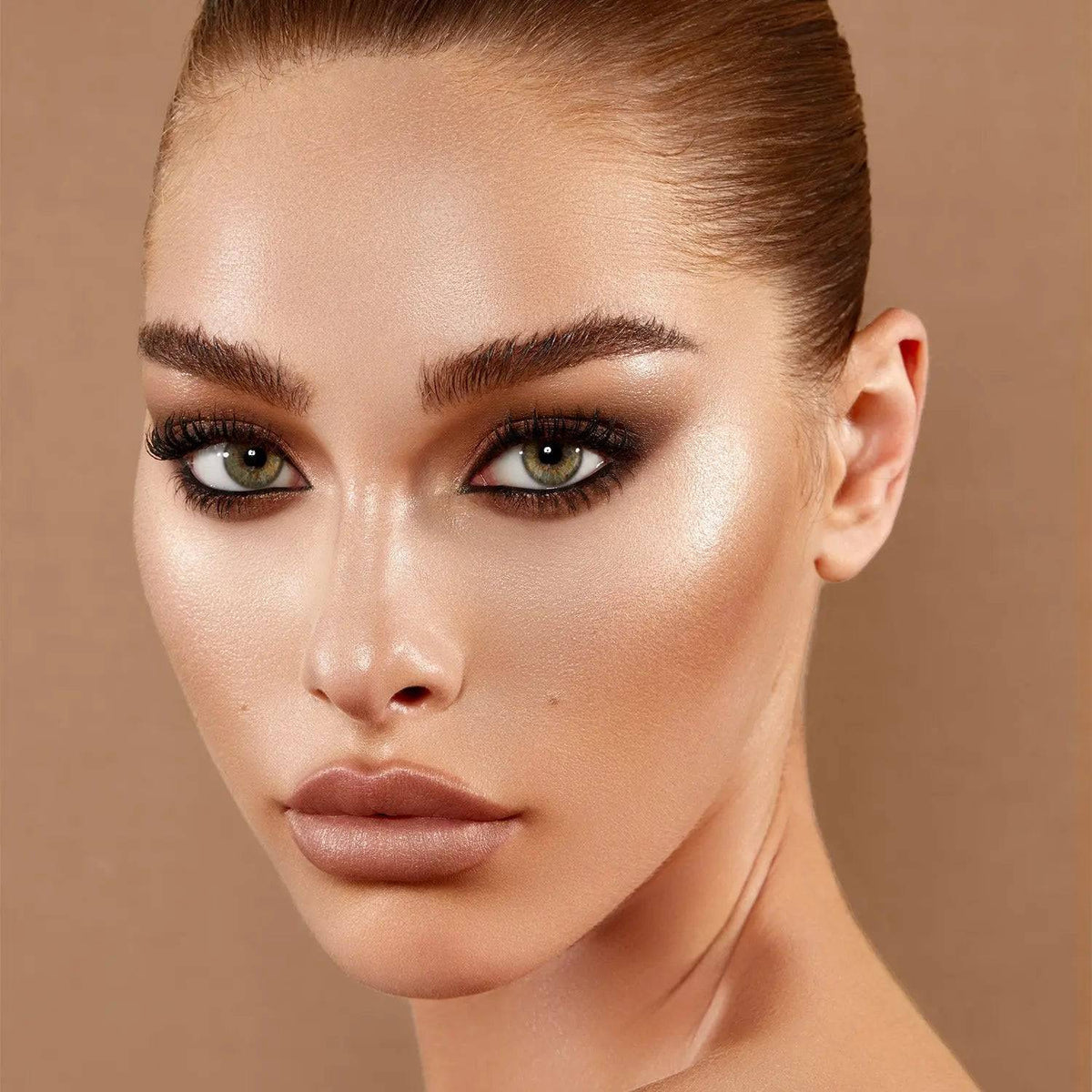 Model wearing Natasha Denona Face Glow highlighter on her cheekbone