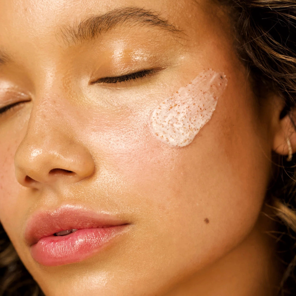 Model with The Feelist Juice Shot facial polish applied to her cheek