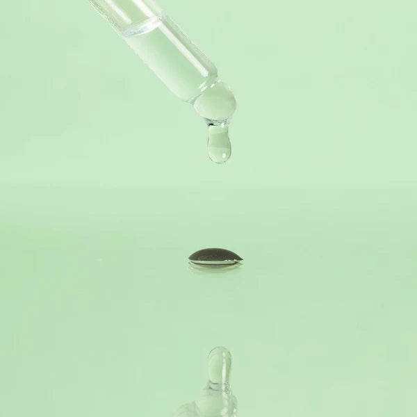 purlisse Glow Revival oil dropper and droplet against a light green background