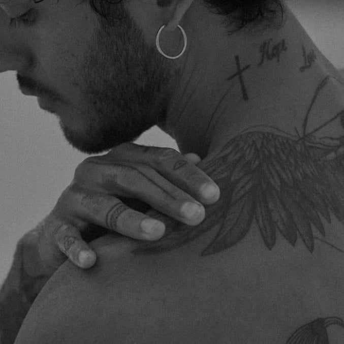 Black-and-white image of a person holding their shoulder for African Botanics Recovery Gel