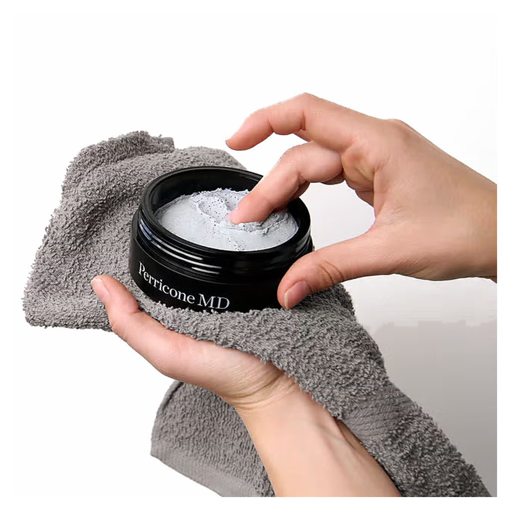 Hands scooping Perricone MD Daily Detox Clay Cleanser from an open jar over a gray towel