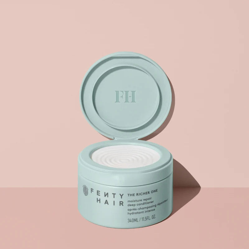 Open mint-green jar of Fenty Hair The Richer One deep conditioner showing white cream against a peach background.