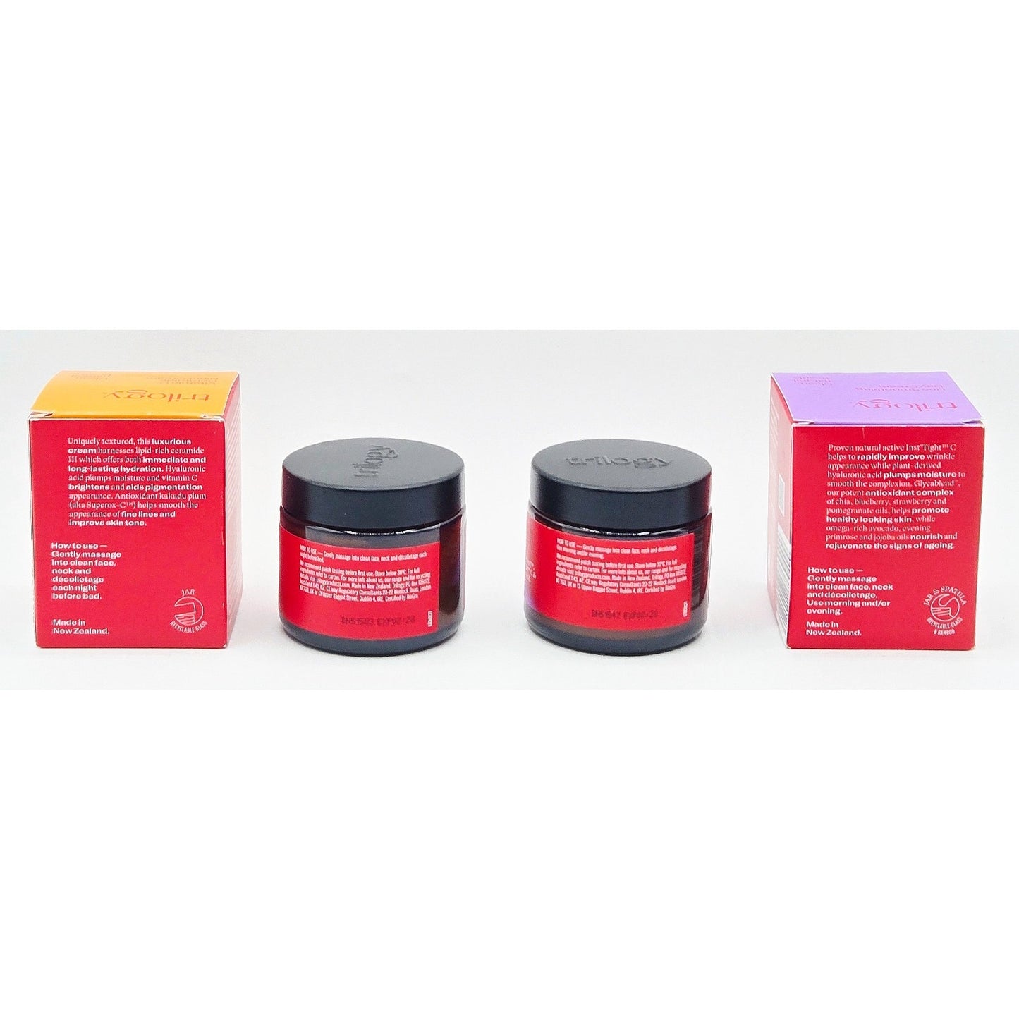 Two red jars with black lids and two matching boxes on a white background
