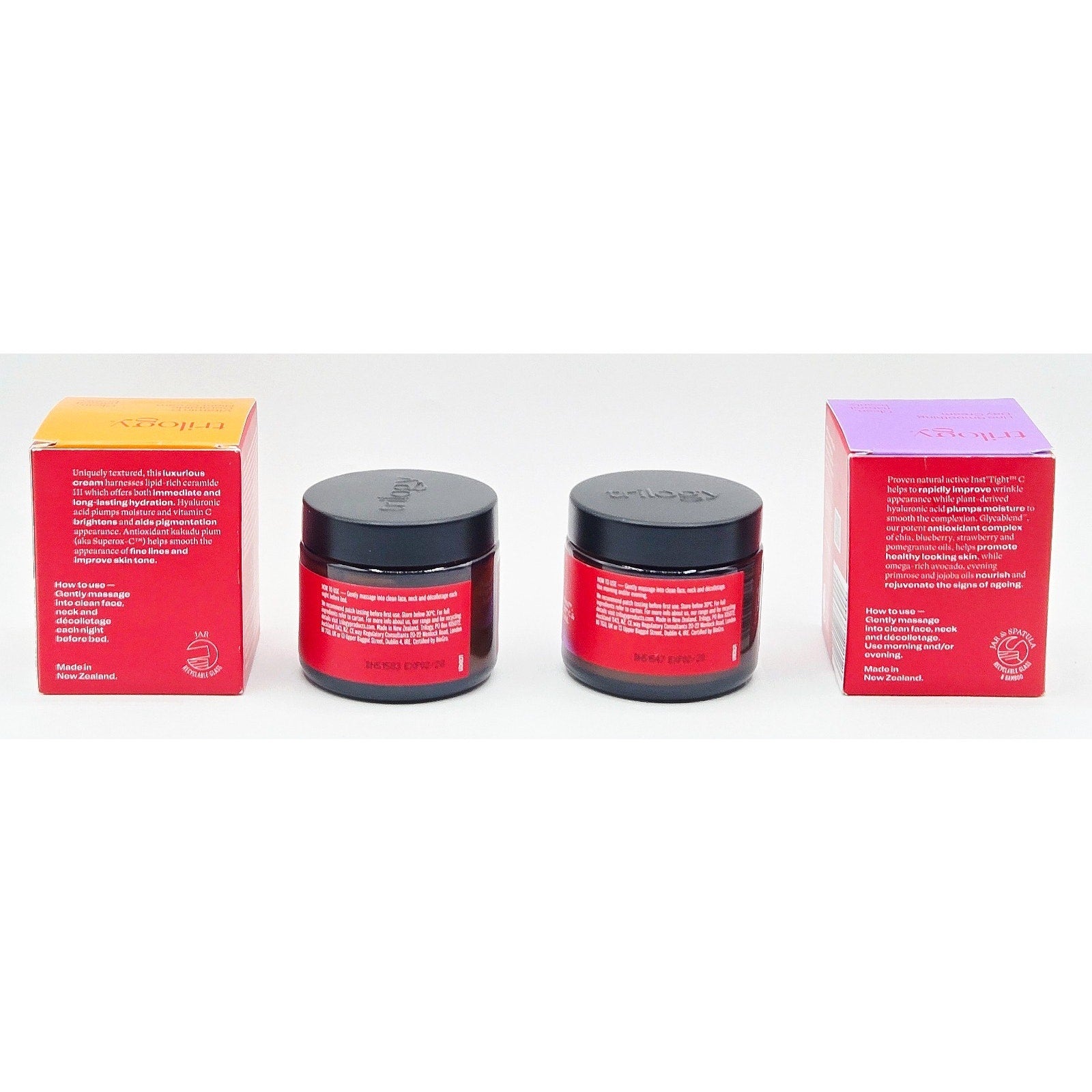 Two red jars with black lids and two matching boxes on a white background