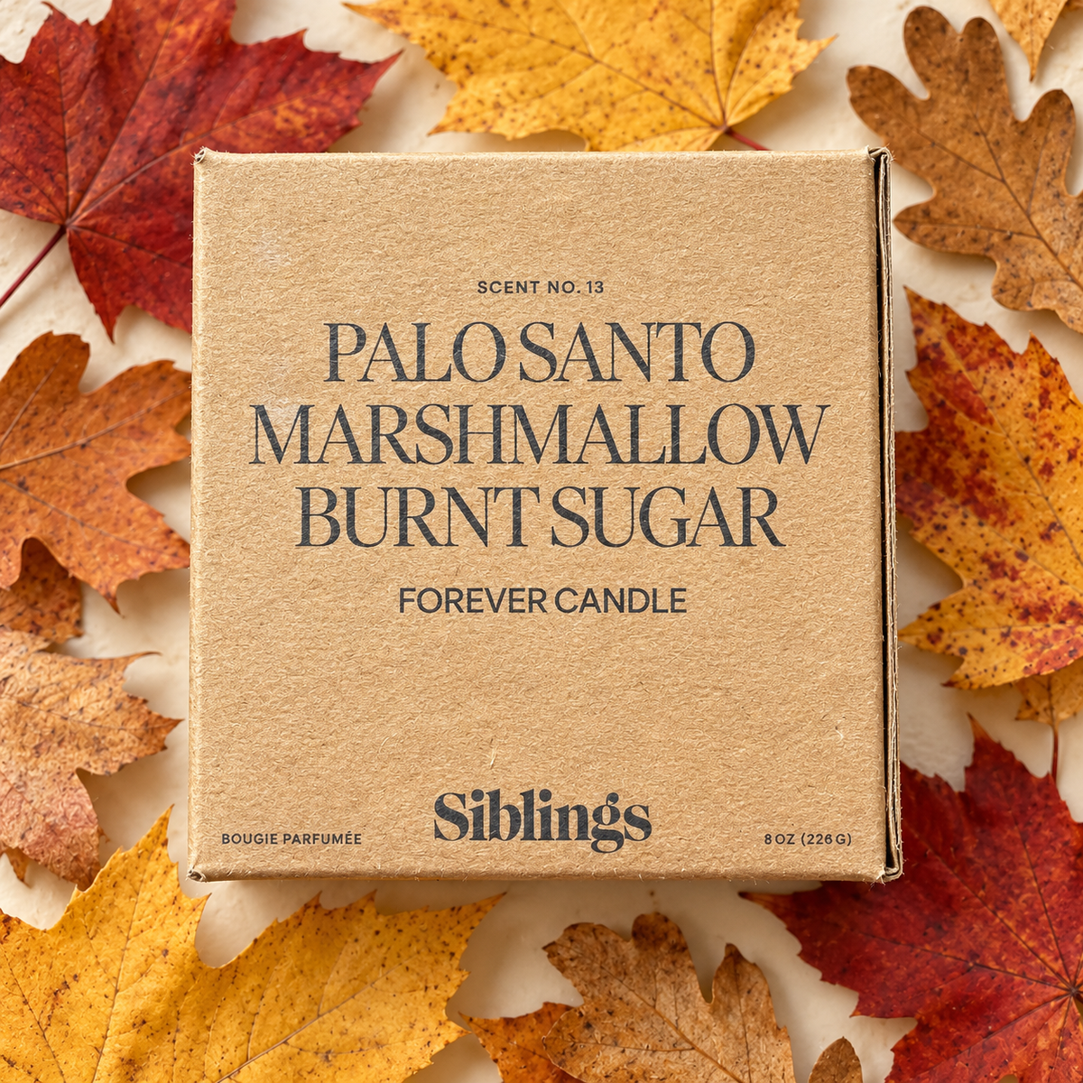 Front of Siblings No. 13 Forever Candle box surrounded by autumn leaves.