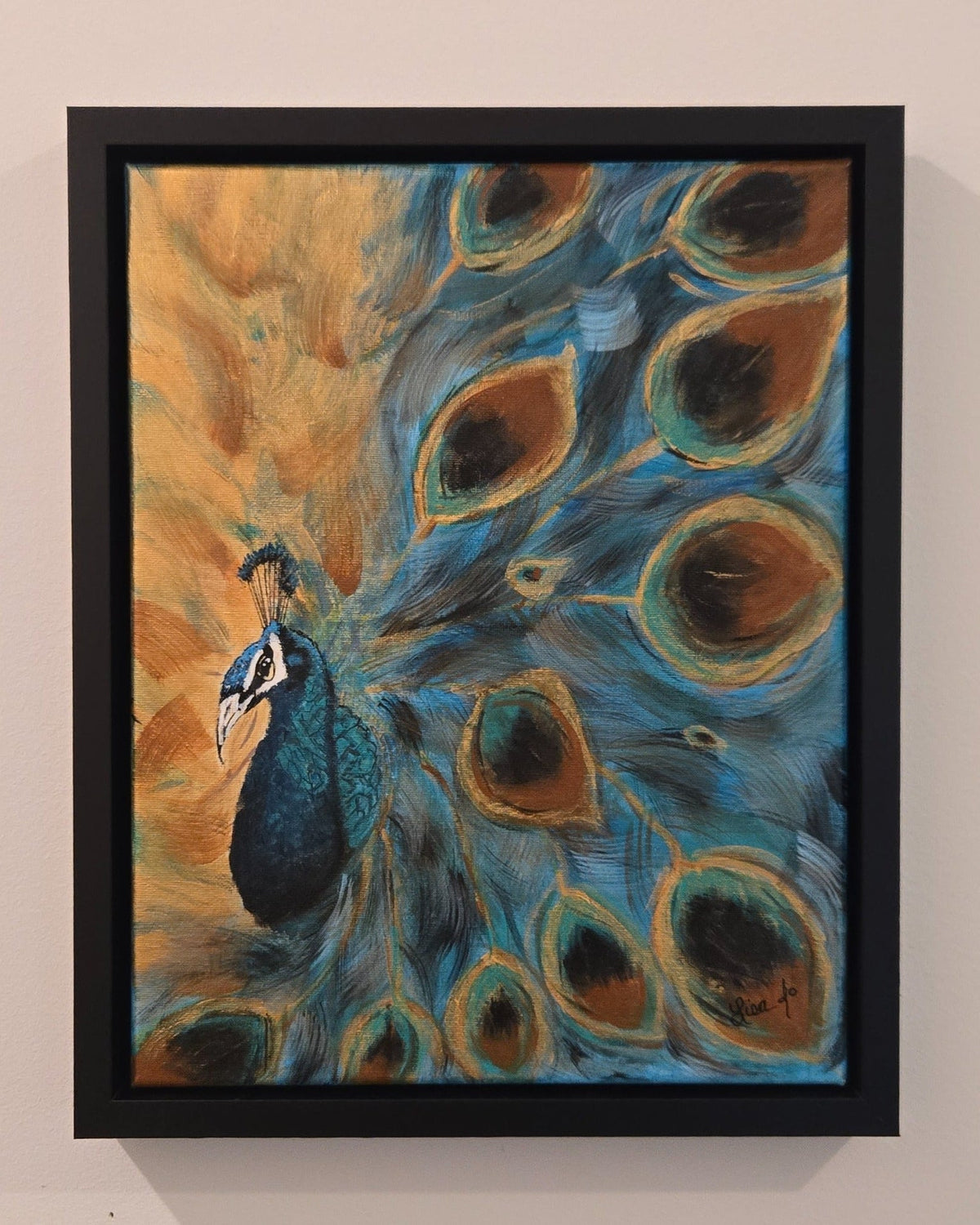 Feathered in Blue peacock painting displayed in its black frame on a wall