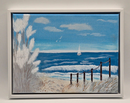 White-framed original acrylic painting Serenity showing a quiet beach, blue waves, rope fence, and distant sailboat