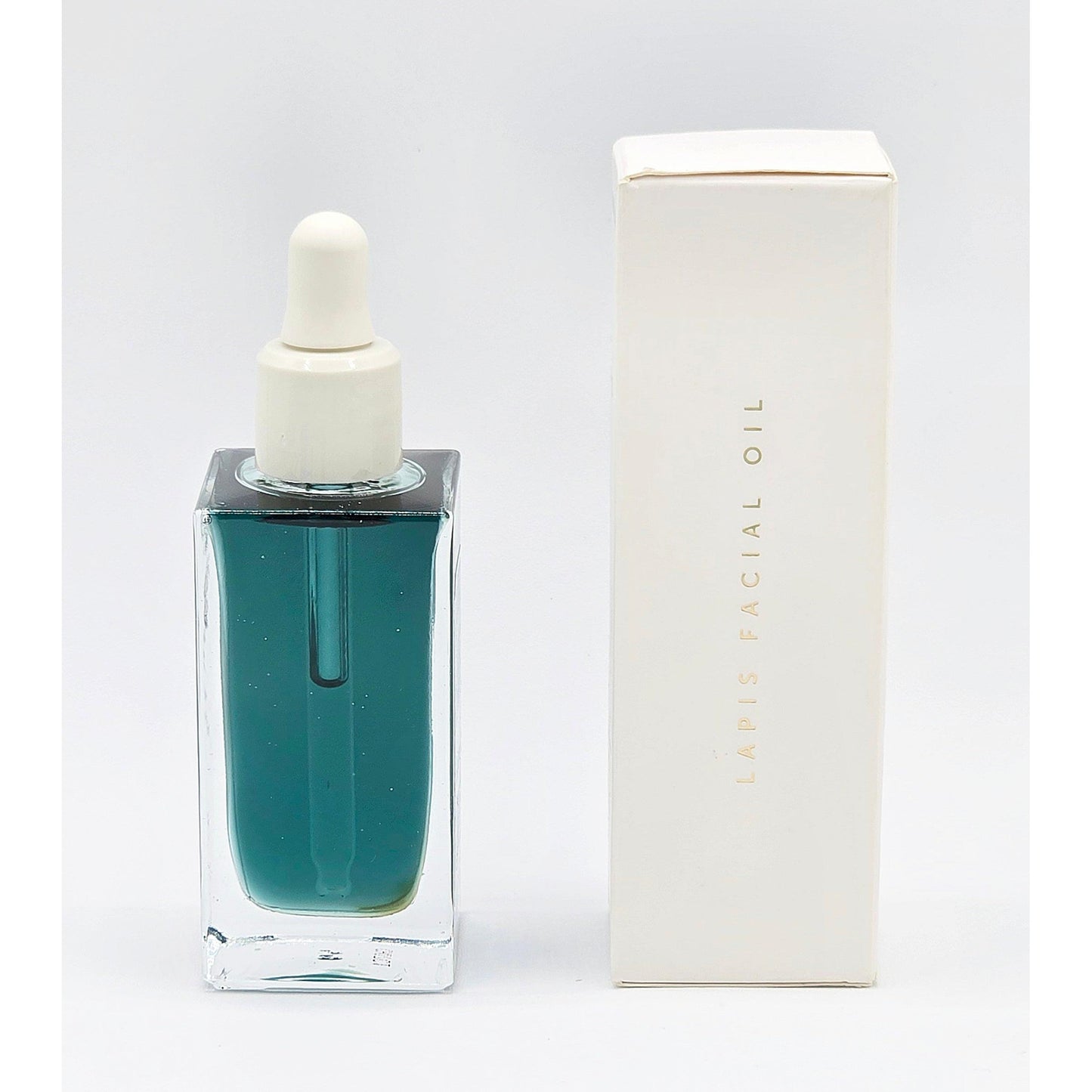 Herbivore Lapis Facial Oil in a rectangular clear glass bottle with a white dropper, next to its white box.