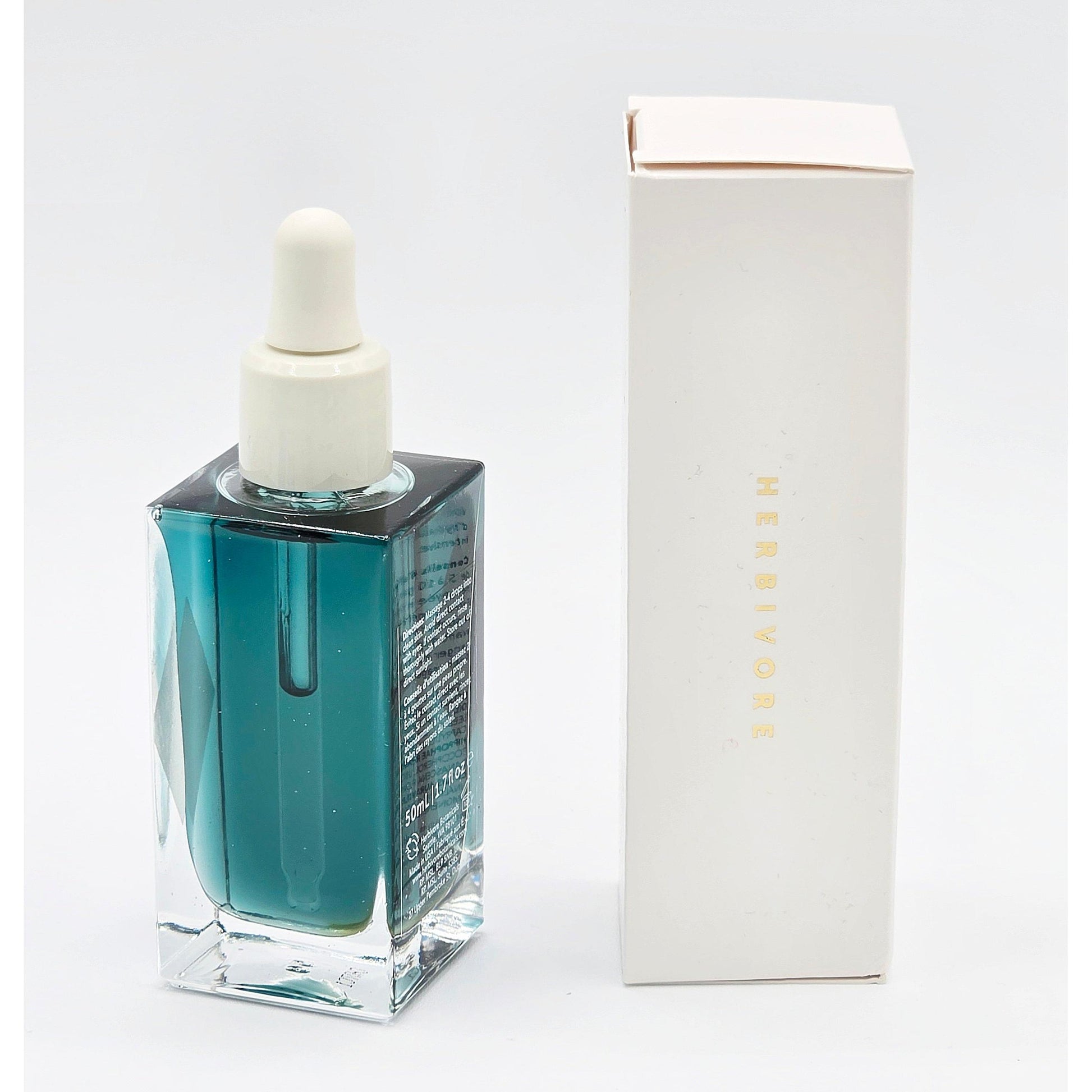 Herbivore Botanicals Lapis Facial Oil in a clear square bottle with a white dropper, next to its white box.