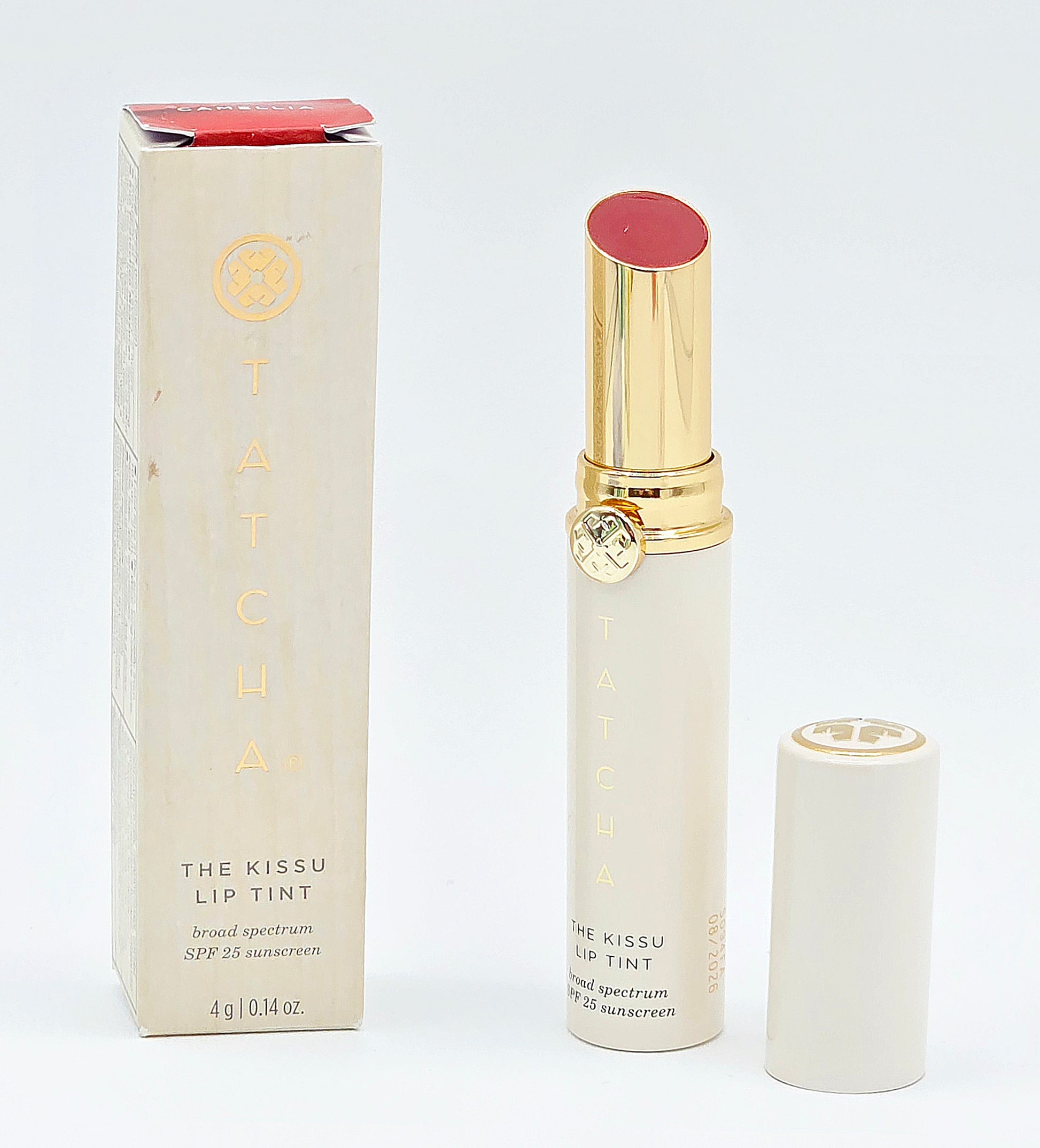 Lip tint with gold cap and white packaging on a white background