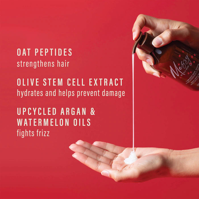 Messy shampoo dispensed into a palm; ingredient graphic highlights oat peptides, olive stem-cell extract, and upcycled argan and watermelon oils.